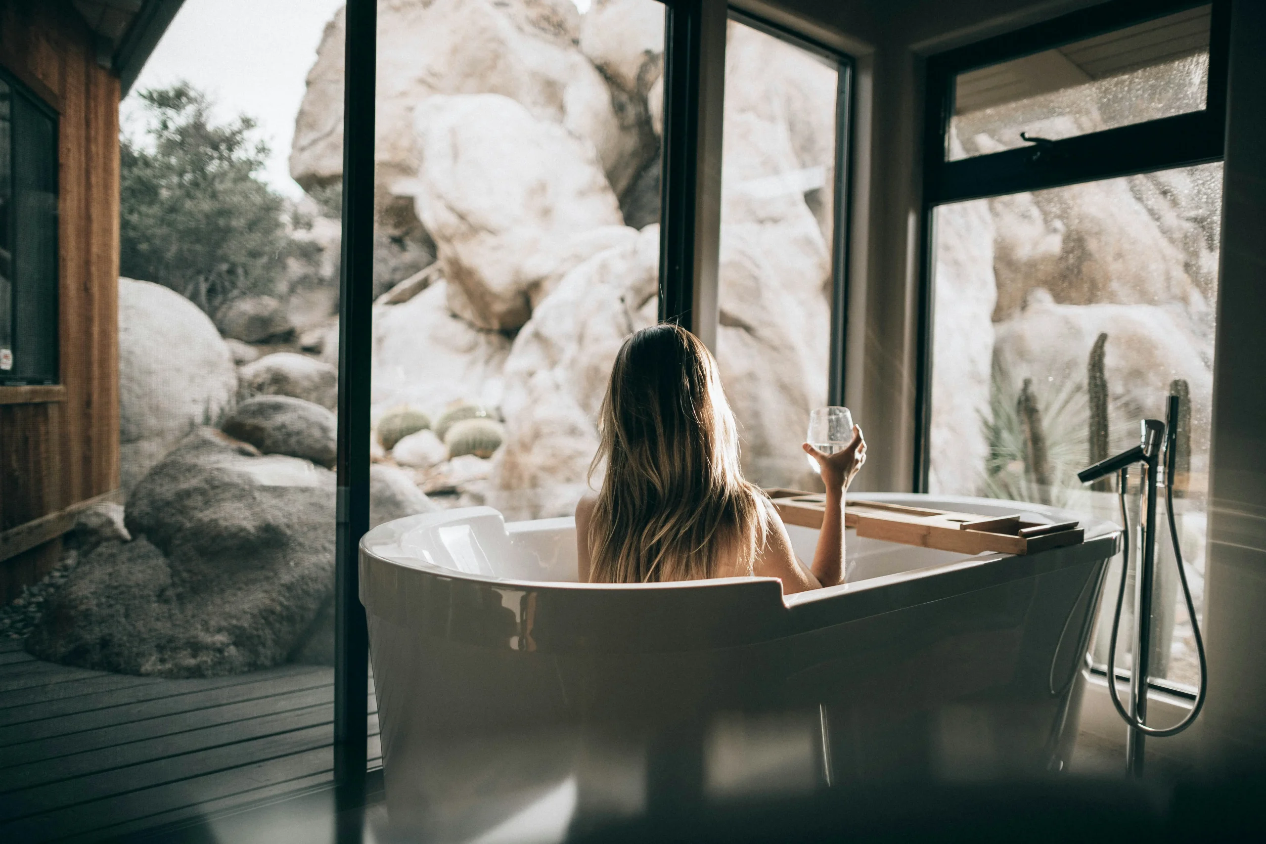 Woman practicing full-body skincare in a bright bathroom